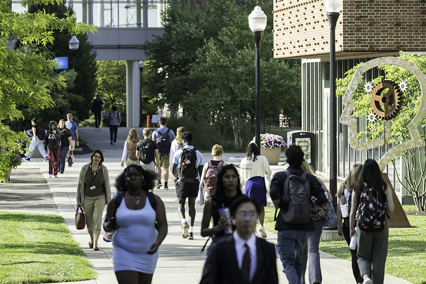 Students walking on campus on a sunny day.